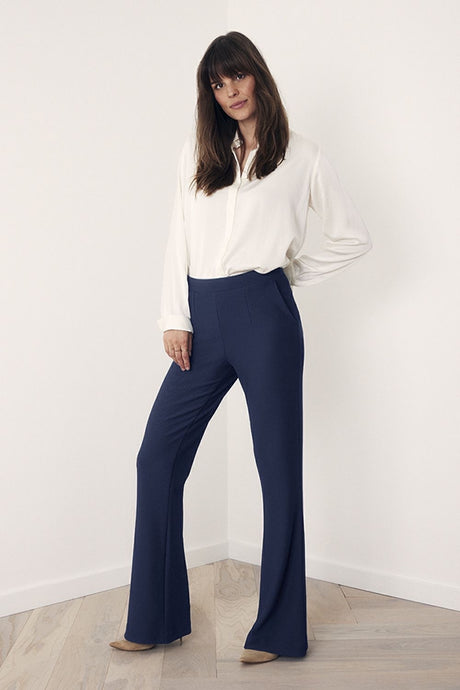 Blauwe Broek van Corel, kleur Marine, model Boa Flare Sport heeft een elastische hoge tailleband sluit naadloos aan op het lichaam en door de uiteenlopende pijpen heeft de broek een flaterend karakter. De broek is gemaakt van een comfortabale, middelzware stretchy materialenmix.