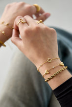 Load image into Gallery viewer, Een goudkleurige armband met massieve hartjes, afgewisseld met zirkonia steentjes. Leuk om cadeau te geven.
