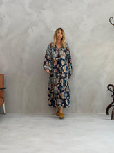 Load image into Gallery viewer, Multicolor Jurk Kerman Milotic van Banditas van Marseille. De lange jurk is een licht klokkend model met bloemmotief, lange ballon mouwen en elastieken manchetten. Deze jurk heeft werkelijk een prachtige print in kleurcombinatie bruine en blauwe tinten. Jurk heeft knoopjes, die zowel gesloten als open gedragen kunnen worden, voor een luchtig effect.
