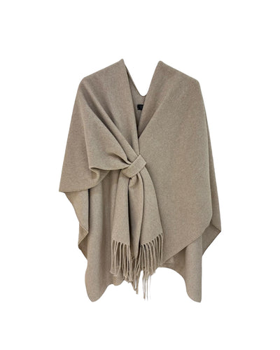 Beige Poncho, Omslagdoek Evi van M&G is een zwaardere poncho in een uni kleur met franjes en kan vastgemaakt worden met een lus. Ideaal voor in de auto! 