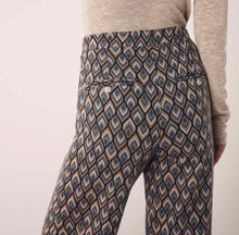Load image into Gallery viewer, Wijde Broek van Corel, Lily Wide Peacock met oog voor detail, een jacquard gebreide peacock dessin in warme tinten. Broek met dé perfecte en zeer mooie vrouwelijke pasvorm. In deze broek heeft namelijk écht iedereen mooie billen. Deze broeken zijn ideaal voor de langere dames, maar zijn ook gemakkelijk korter te maken.
