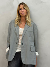 Load image into Gallery viewer, Elegante mouwloze uitgewerkte top in ecru. Deze top heeft een stijlvolle en opvallende uitstraling, perfect voor onder een blouse of blazer. Combineer hem moeiteloos met een jeans, legging of rok en voeg direct een fashionable touch toe aan je outfit.

