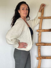 Load image into Gallery viewer, Ecru Vest Luxe Raha is een heerlijk zacht grof gebreid vest met een rib gebreide boord aan de onderkant en onder aan de mouwen. Het vest heeft lange mouwen met strakke manchetten. Vest Luxe Raha is verkrijgbaar in één maat, geschikt voor maat S t/m L, in verschillende kleuren: Ecru, Camel, Donkerblauw, Lichtroze.
