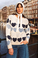 Afbeelding in Gallery-weergave laden, Gebreide Trui met Hartjes.
Deze zachte, gebreide trui straalt warmte en speelsheid uit dankzij het patroon van hartjes in verschillende tinten blauw en ecru. De zorgvuldig gekozen kleuren – van diep marineblauw tot licht pastelblauw – vormen samen een harmonieus geheel dat subtiel contrasteert met het ecru. Het hartjesmotief loopt gelijkmatig over de trui, waardoor een charmante en unieke uitstraling ontstaat.
