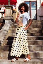 Load image into Gallery viewer, Maxi Rok Norma is een elegante, zachtgele lange rok met speelse donkerblauwe stippen. De rok heeft een comfortabele elastische tailleband, waardoor hij mooi aansluit en prettig draagt. Dankzij de praktische steekzakken combineert Rok Norma stijl met gemak,  perfect voor zowel een casual als een meer geklede look.
