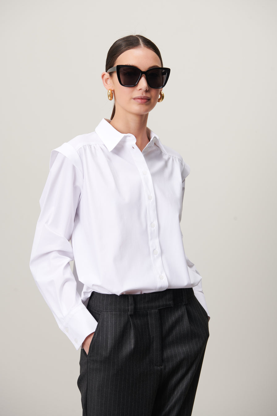 Witte Blouse Hanna is een casual blouse van Jane Luskha, heeft lange mouwen met manchetten, subtiele ruches op de schouders en een kraag. Deze prachtige blouse is ook ontzettend mooi om te dragen op een donkere broek of onder een pak. De blouse is van de bekende travel kwaliteit en is verkrijgbaar in maat S t/m XXL.