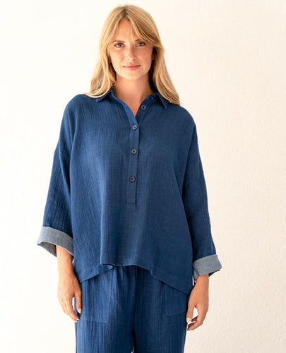 Blauwe Blouse Camille van de Moment Amsterdam Collectie is vervaardigd van een mooie kwaliteit katoen in de diepe kleur indigo. Deze klassieke blouse heeft een kraag, knopen tot halverwege en uitlopende lange mouwen.