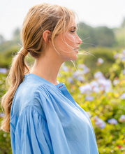 Load image into Gallery viewer, Blauwe Blouse Jasmin van de Moment Amsterdam Collectie is een wijde translucent blouse met een ronde hals, lange mouwen met plooitjes en bedekte knoopjes. Deze moderne blouse is een klokkend model met plooitjes. Een fijne blouse die je heerlijk door kunt dragen.
