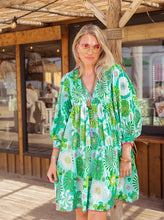 Afbeelding in Gallery-weergave laden, Groene Jurk van Place du Soleil. De Green Flower Power Dress is een prachtige uitlopende korte jurk met pailletten. Jurk heeft een V-hals met 3/4 mouwen met manchet, steekzakken en prachtige print. Wat een plaatje deze jurk! Deze jurk valt wat groter op maat.
