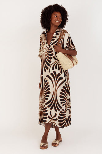 Maxi Jurk Print Kapa is een lange jurk van Viscose met een prachtige print in zwart en bruin tinten. De jurk heeft een V-hals, een kraag en korte mouwen met omslag. Jurk valt ruim en is te dragen van maat S t/m XXL. Dé ideale zomerjurk, als je stijlvol voor de dag wilt komen.