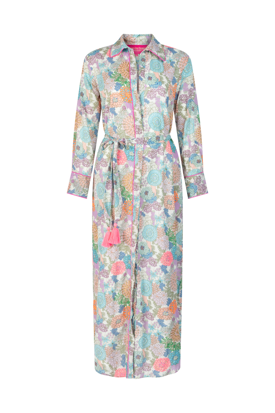 Maxi Jurk van Place du Soleil, Green Rosa Blue is een prachtige lange doorknoopjurk met (vaste) onderjurk, lange mouwen met manchetten en een losse ceintuur met fluo roze flosjes. De jurk heeft een prachtige oudroze bies aan de kraag en langs de knoopjes. Deze jurk heeft een prachtige bloemenprint, sommige bloemen zijn geborduurd met lurex draad, andere bloemen met prachtig gekleurd embroiderie.