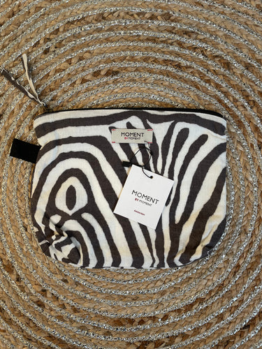 Handig mini tasje met rits, van Moment by Moment in een vale zwart/wit print zebra dessin. In deze serie is verkrijgbaar: zomerjurk, super grote strandtas, te sluiten met een strikje en een mini tasje met rits. Met deze prachtige set ben je helemaal klaar voor het strand of het terras.