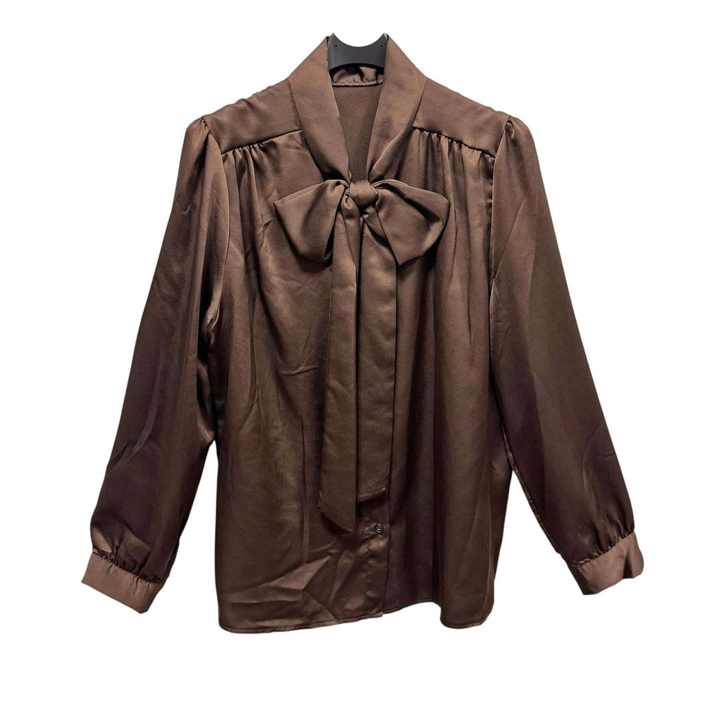 Bruine Glanzende Satijnen Blouse met Pofschouders en Strik. Elegante blouse van glanzend satijn met vrouwelijke pofschouders en een striksluiting bij de hals. De soepele stof valt mooi om het lichaam en geeft elke outfit een stijlvolle, luxueuze look. Perfect voor zowel feestelijke gelegenheden als een chique kantooroutfit.