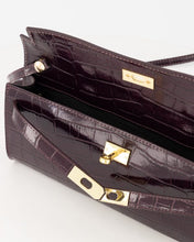 Load image into Gallery viewer, Bordeaux kleurige Tas Palermo Croco is een leren handtas met chique crocoprint en subtiele glans. Tas die ook gedragen kan worden als clutch en als schoudertas door middel van een lang hengsel, welke bevestigd wordt met drukkers. De tas heeft een hoofdvak met een klein ritsvak en wordt gesloten door middel van een uniek systeem met draaisluiting.
