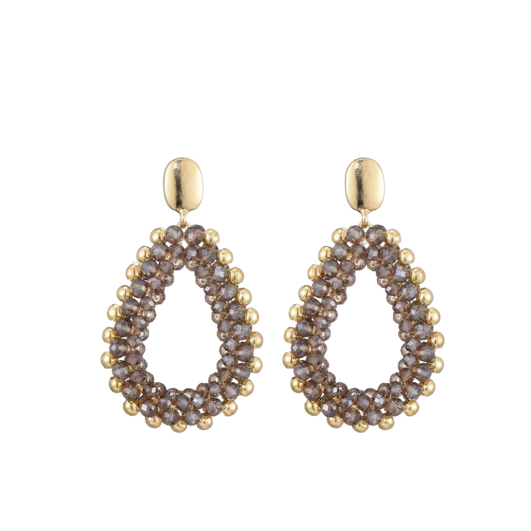 Taupe Oorbellen Yara zijn prachtig vormgegeven in de vorm van een druppel, met sierlijke taupe en gouden kraaltjes.