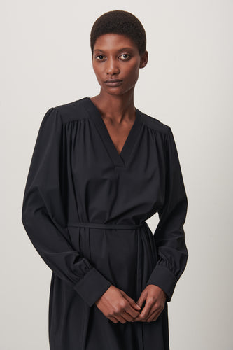 Zwarte Jurk Lizette is een klassieke jurk met lange mouwen van de Jane Luskha Collectie. Jurk heeft een V-hals aan de voorkant en een smal ceintuur van dezelfde stof (geen lussen) om de jurk te strikken en kleine splitjes aan beide zijden onderkant.  Mooie jurk door eenvoud en voor vele gelegenheden te dragen.  De jurk is uitgevoerd in de kleur zwart en is van de bekende travel kwaliteit.