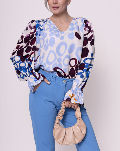 Blauwe Blouse Print met V-hals van de Soft Collectie Chastar. Viscose Blouse Circle Blue is een frisse en moderne top met cirkels van een zachte stof. De blouse heeft smok schouders, elastiek in de mouwen en is verkrijgbaar in combinatiematen. Viscose Blouse Circle is verkrijgbaar in verschillende kleuren: blauw, groen, fuchsia.