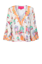Load image into Gallery viewer, Witte Top, Tents Wide Sleeves van Place du Soleil. De blouse is een klokkend model, heeft wijde trompetmouwen met prachtig fluo oranje embroiderie en pailletten. Deze geweldige blouse is gevoerd, heeft een diepe V-hals met strikdetail en fluo oranje flosjes. Op deze top zijn afbeeldingen te zien van circustenten, in een prachtige oudroze kleur in combinatie met groen, blauw, oranje en roze.
