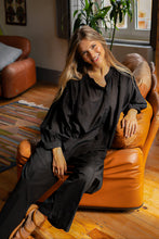 Load image into Gallery viewer, Zwarte Blouse Jasmin van de Moment Amsterdam Collectie is een wijde translucent blouse met een ronde hals, lange mouwen met plooitjes en bedekte knoopjes. Deze moderne blouse is een klokkend model met plooitjes. Een fijne blouse die je heerlijk door kunt dragen. Blouse Jasmin is verkrijgbaar in verschillende kleuren: black, french blue.
