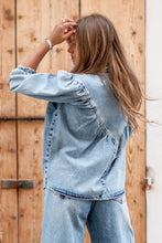 Afbeelding in Gallery-weergave laden, Denim Blouse Pancha Blue van ibzmode heeft een kraagje, sluit met de knopen, heeft gerafelde afwerkingen, elastiek bij de polsen en is geplooid bij de borsten. De gerafelde afwerkingen en elastiek bij de polsen geven een speelse twist aan het klassieke ontwerp. Verkrijgbaar in verschillende kleuren: Off White, Blue.
