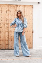 Afbeelding in Gallery-weergave laden, Denim Blouse Pancha Blue van ibzmode heeft een kraagje, sluit met de knopen, heeft gerafelde afwerkingen, elastiek bij de polsen en is geplooid bij de borsten. De gerafelde afwerkingen en elastiek bij de polsen geven een speelse twist aan het klassieke ontwerp. Verkrijgbaar in verschillende kleuren: Off White, Blue.
