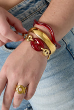 Load image into Gallery viewer, Deze elegante goudkleurige schakel armband met prachtige 'bean’ in bordeaux rood is een echte blikvanger. 
