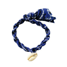 Load image into Gallery viewer, Armband van gevlochten stof met een schelpje als bedel. Armband is verkrijgbaar in verschillende kleuren: kobaltblauw, groen, roze, lichtblauw. 
