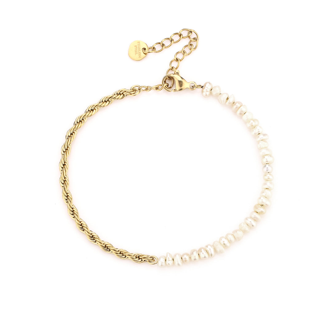 Armband Twisted Rope & Pearls is een elegant en verfijnd sieraad. De lengte van de armband is 16cm, in goudkleurig stainless steel gecombineerd met kleine parels.