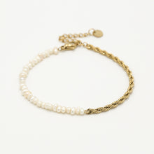 Load image into Gallery viewer, Armband Twisted Rope &amp; Pearls is een elegant en verfijnd sieraad. De lengte van de armband is 16cm, in goudkleurig stainless steel gecombineerd met kleine parels.
