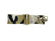 Afbeelding in Gallery-weergave laden, Witte Bagstrap, schouderband voor aan een tas met trendy legerprint. Deze schouderband heeft een lederen uiteinde in de kleur zilver. De band is 5cm breed en is verstelbaar in de lengte. Minimale lengte , inclusief clips, is 84cm en de maximale lengte, inclusief clips is 125cm. De schouderband Leger is in verschillende kleuren verkrijgbaar: oranje/blauw/goud, zwart/grijs/goud en zwart/wit/goud.
