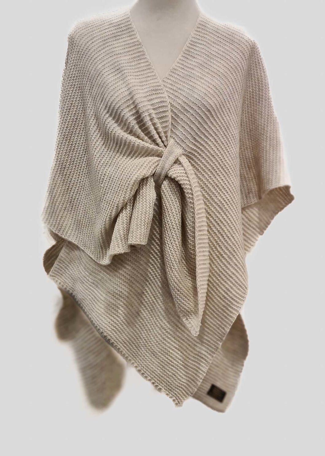 Beige omslagdoek, poncho is gebreid en kun je heerlijk over je schouders heen slaan en kan ook vastgemaakt worden door een punt door een lus te trekken. De Poncho is het gehele jaar door te dragen.  