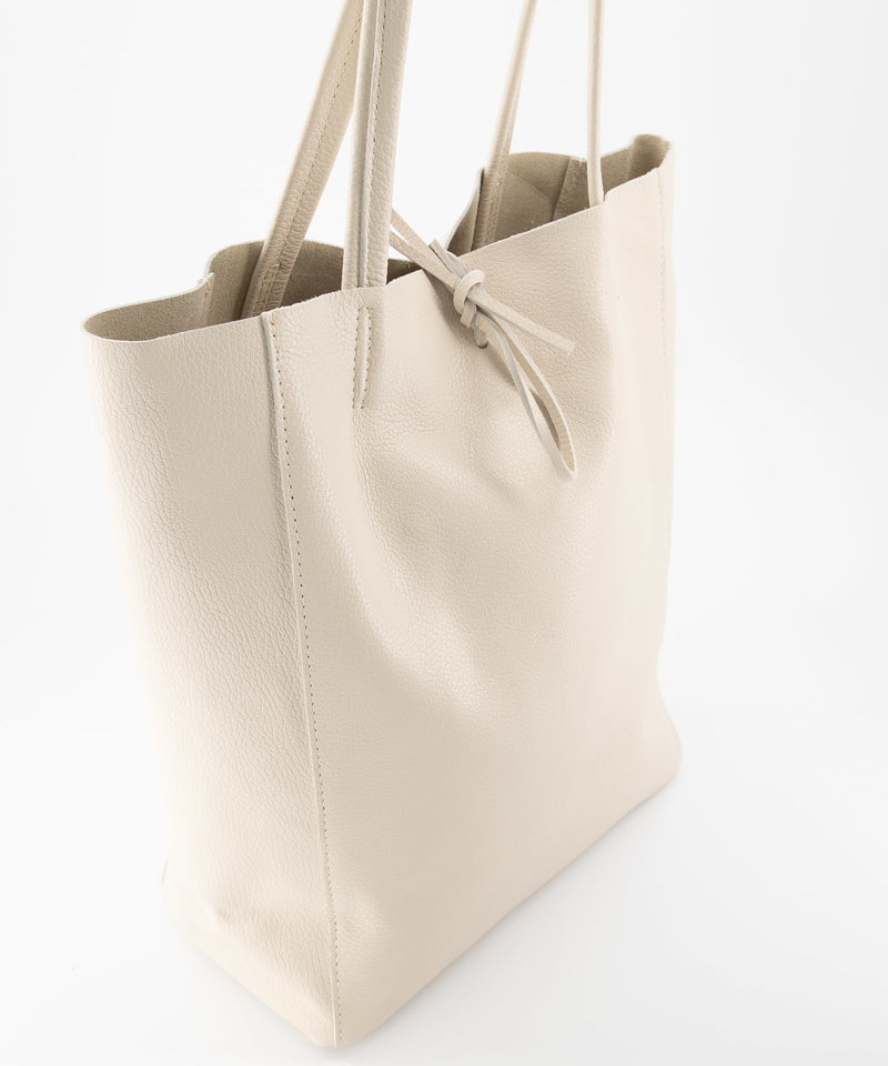 Ecru Lederen schoudertas Mia is een soepel vallende shopper met knoopsluiting en heeft aan de binnenkant van de tas een extra tasje met ritssluiting. Deze schoudertas is verkrijgbaar in verschillende kleuren: Kelly Green suède, Groen suède, Bruin suède, Cheetah suède, Terra, Ecru. Deze lederen suède shopper handtas is waterproof behandeld, maar wees voorzichtig met water. Afmeting tas is 40cm x 13cm x 35cm.